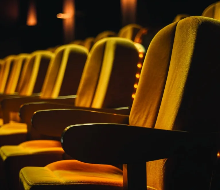 Rows of golden cinema seats in a darkened theatre